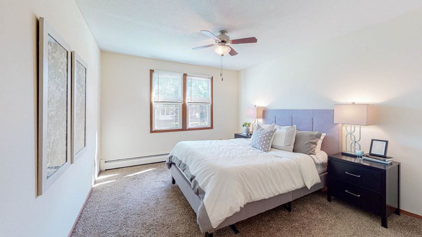 a bedroom with a large bed and a ceiling fan