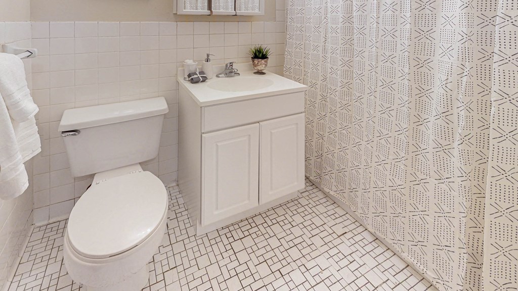 a white bathroom with a toilet and a sink