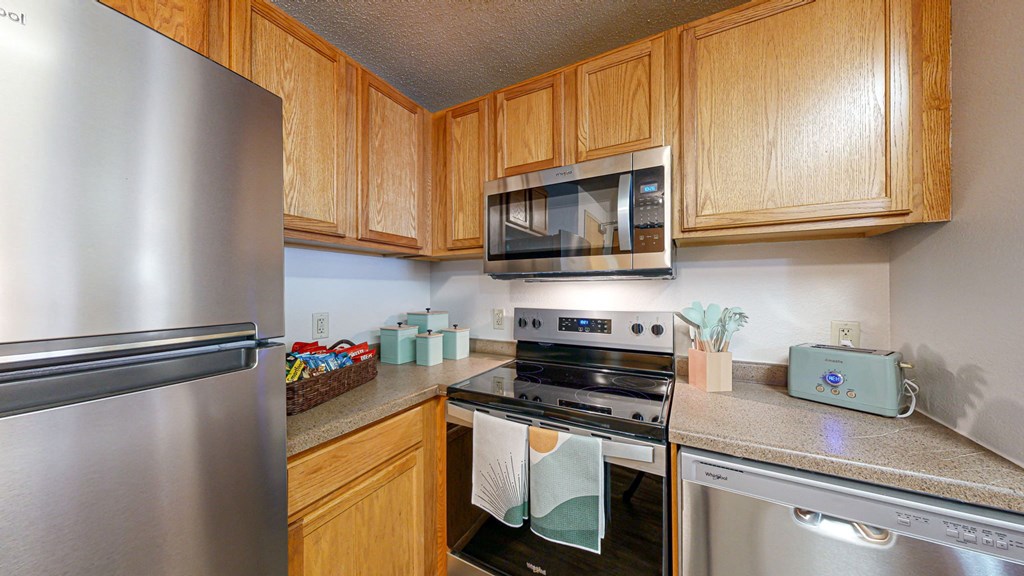 a kitchen with stainless steel appliances and wooden cabinets at Bierman Place, Minneapolis, MN