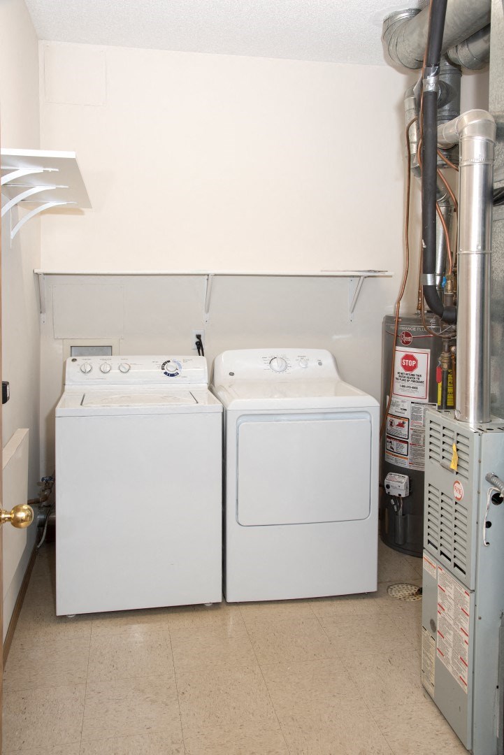 Laundry room with full size washer and dryer and shelving