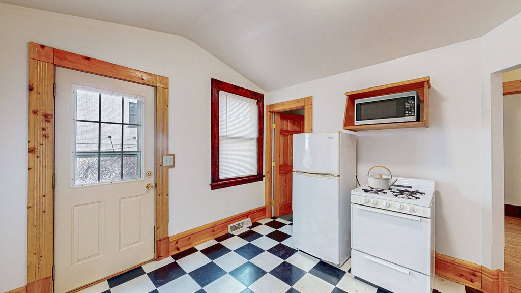 A kitchen with a white stove and a white refrigerator.