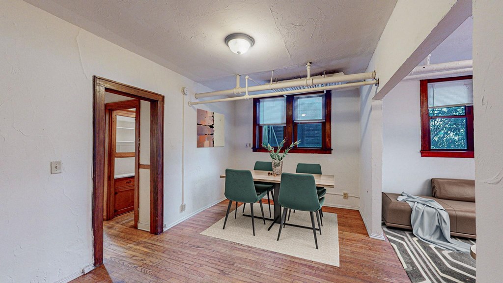 A room with a dining table and chairs.