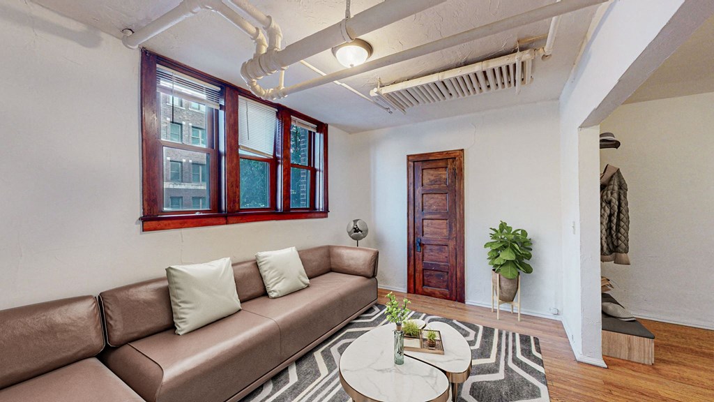 A living room with a brown couch and a white coffee table.