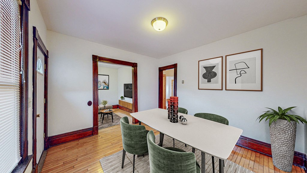 A dining room with a white table and green chairs.