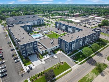 A large apartment complex with a swimming pool in the middle.