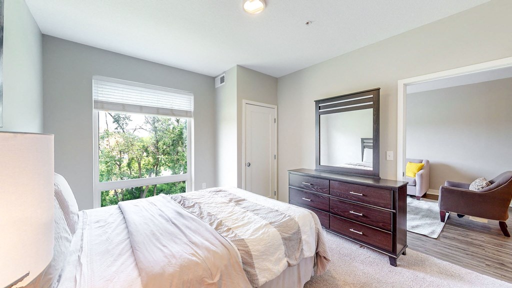 a bedroom with a bed and a dresser and a window