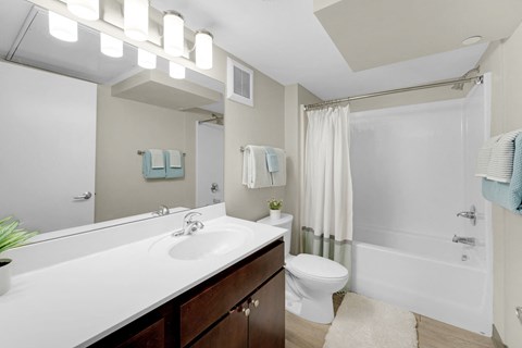 A white sink with a mirror above it and a white toilet next to it.