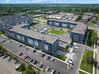 A large parking lot is in front of a multi-story building.