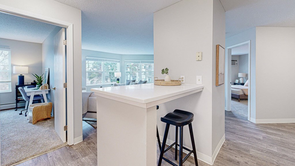 a kitchen with a counter top and a bar with two stools