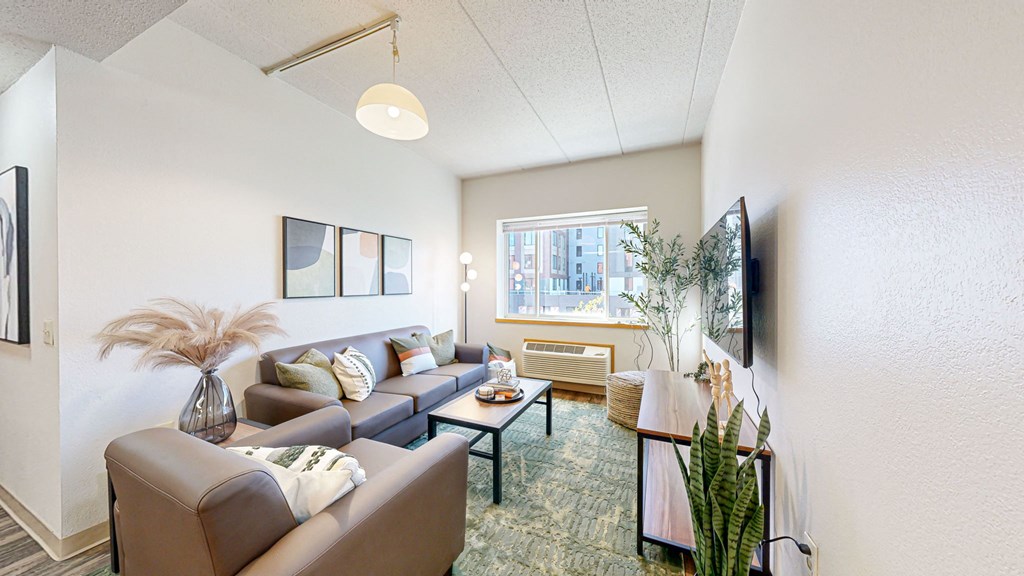 a living room with couches and a table and a window