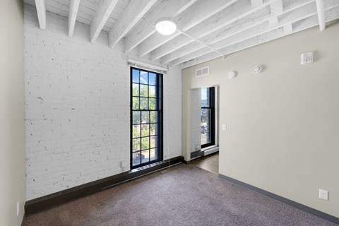 A room with a white brick wall and a window.