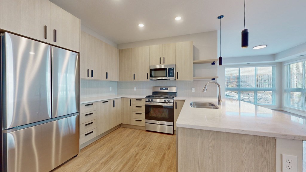 a white kitchen with stainless steel appliances and white counter tops