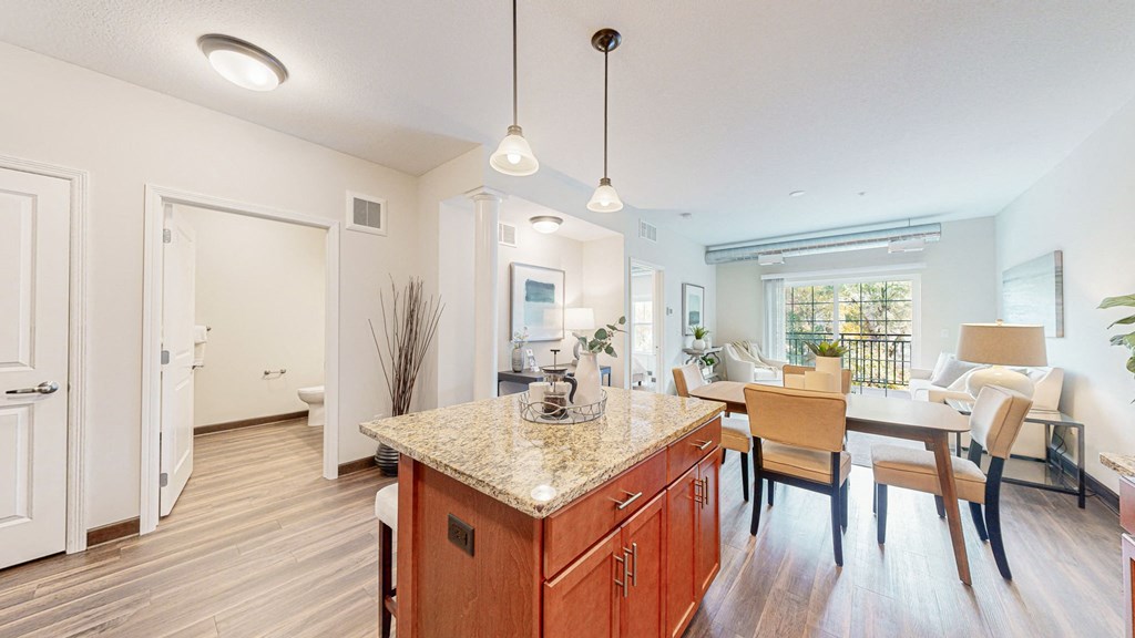 a kitchen with a marble counter top and a dining room table at Victoria Flats, Victoria, Minnesota