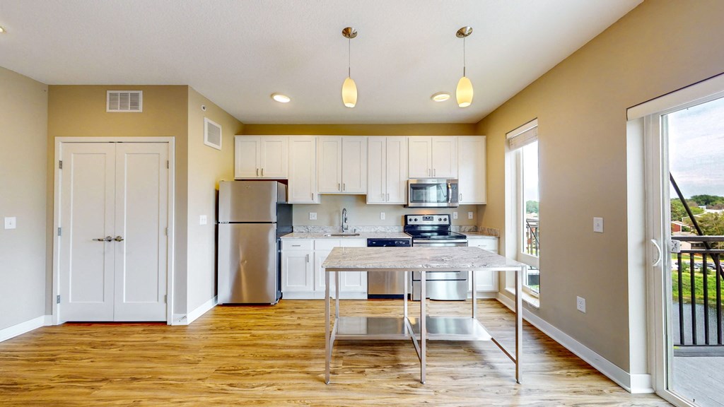 a kitchen with a island and a stainless steel refrigerator