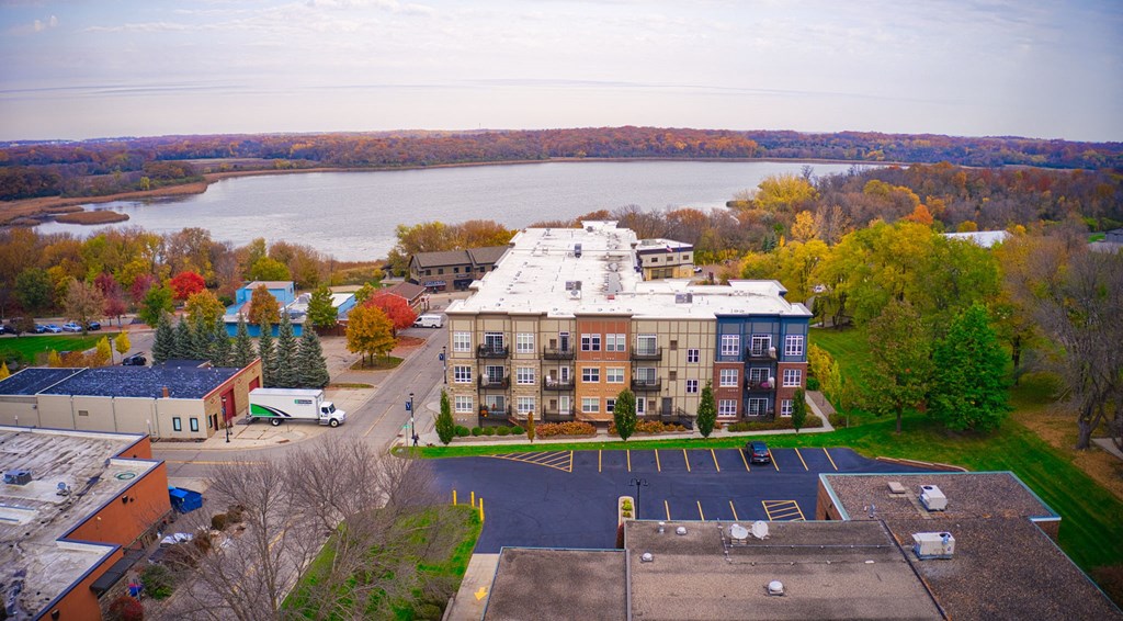 an aerial view of a building with a lake in the background at Victoria Flats, Victoria, MN