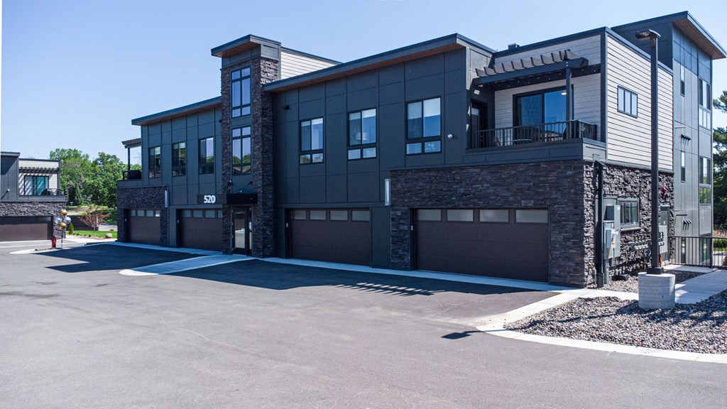 a large building with a driveway and garage doors