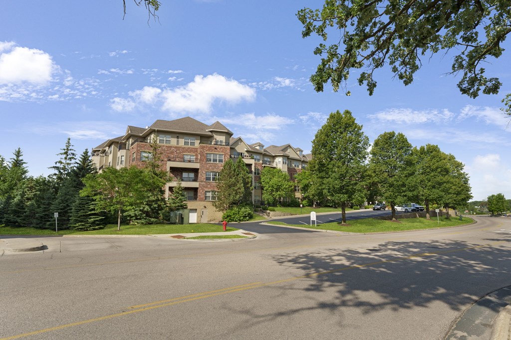 an apartment building on the corner of a street with trees