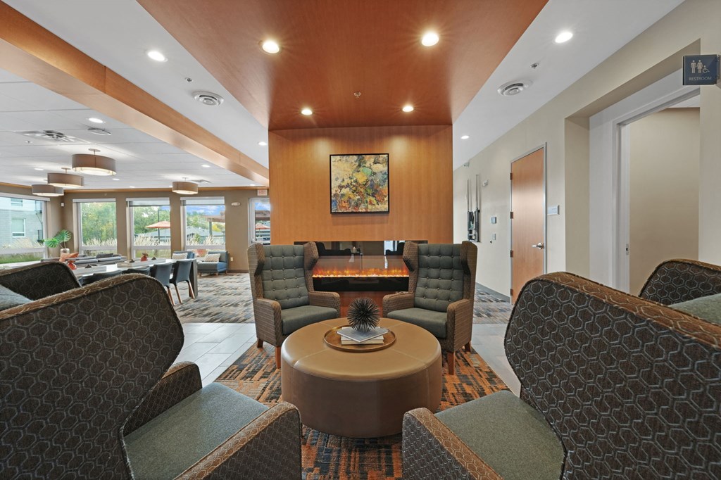 a lobby with couches and chairs and a table with a plant on top of it