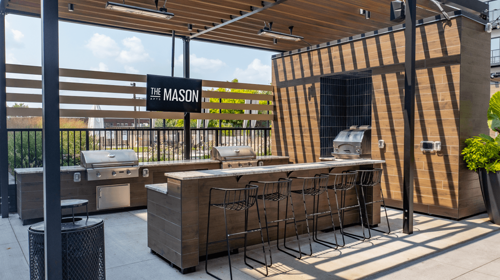 an outdoor patio with a grill and a bar