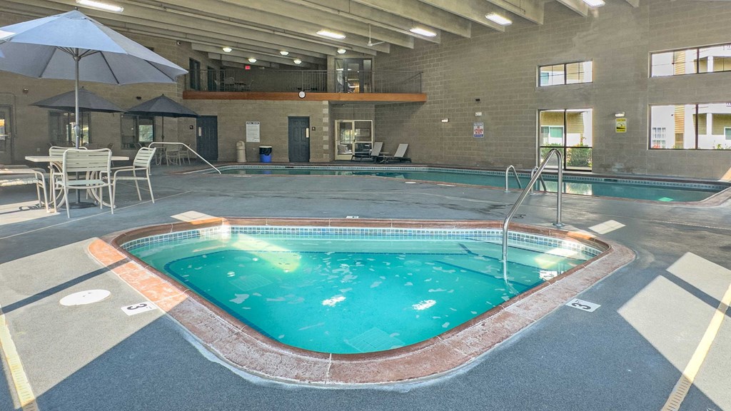 indoor spa and pool with seating and balcony