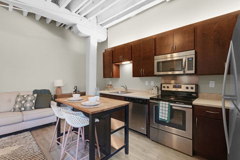 A kitchen with a table and chairs and a couch.