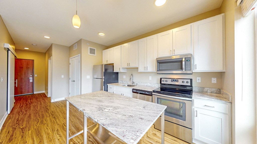 a kitchen with stainless steel appliances and a marble counter top