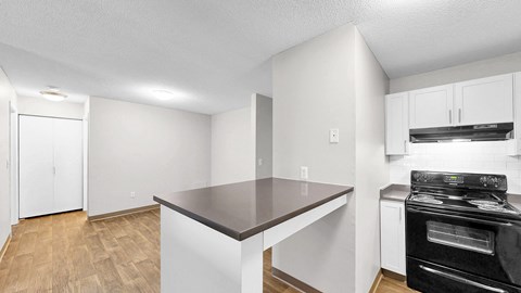 A kitchen with a black stove top oven and white cabinets.