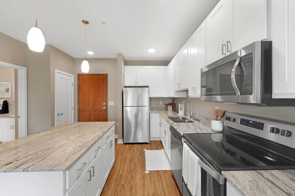 a kitchen with white cabinets and a wooden floor