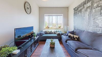 spacious living room with large window and air conditioning unit