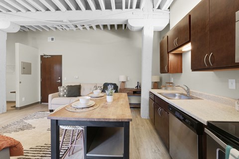 A kitchen with a table set for two and a dining area.