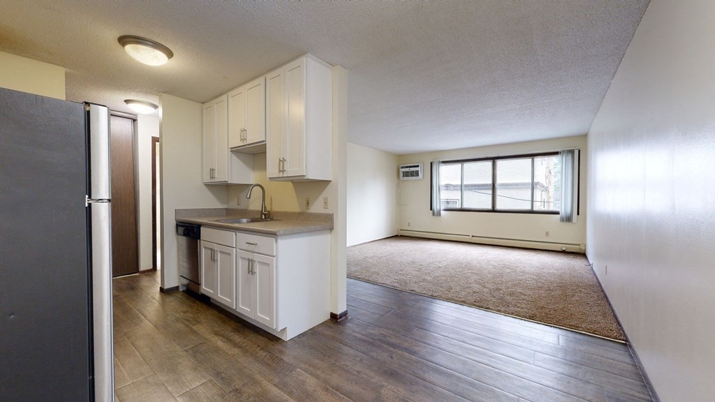 an empty living room with a kitchen