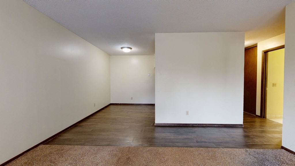 a bedroom with white walls and a dark wood floor