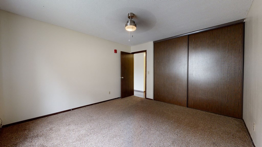 a bedroom with a closet and a ceiling fan