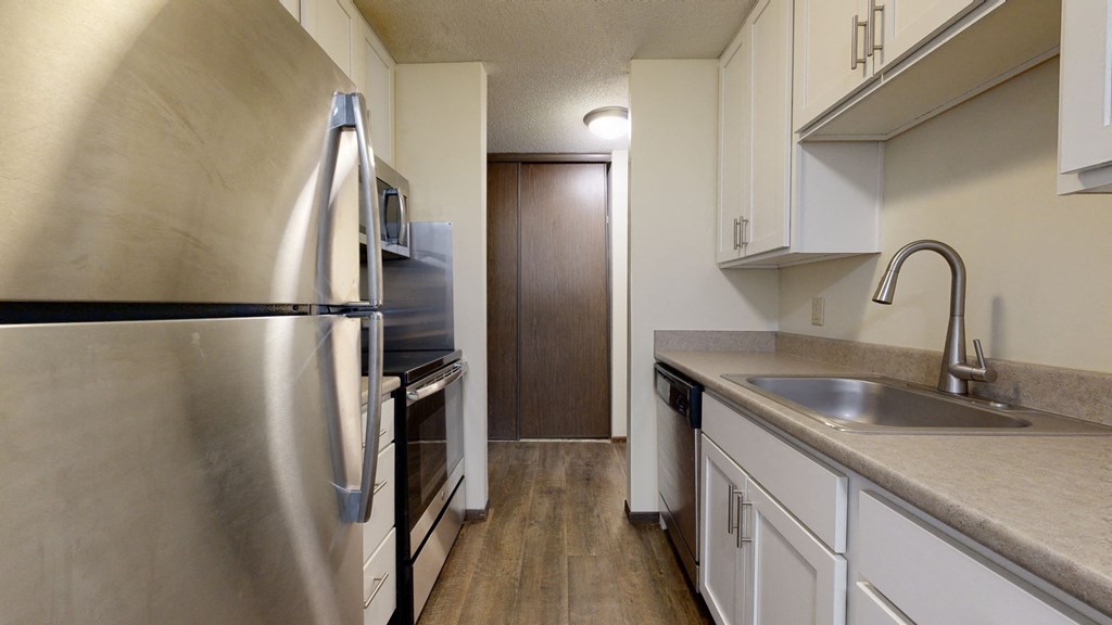 a kitchen with white cabinets and stainless steel appliances