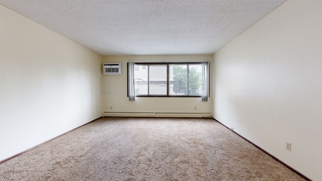 a bedroom with white walls and a large window