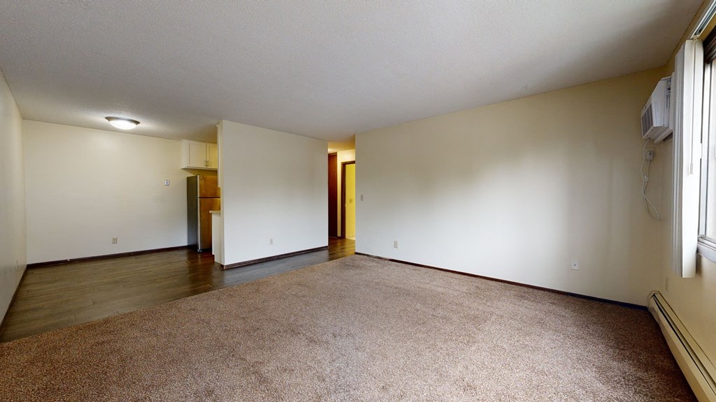 an empty living room with white walls and a beige carpet