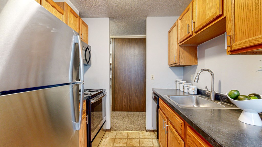 a kitchen with wooden cabinets and stainless steel appliances