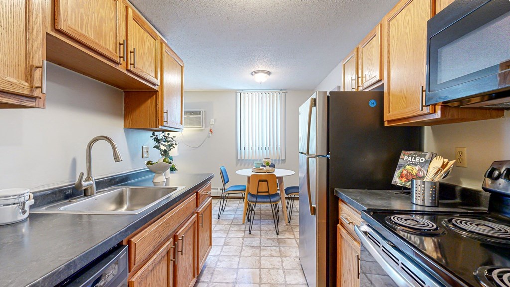 a kitchen with black countertops and wooden cabinets