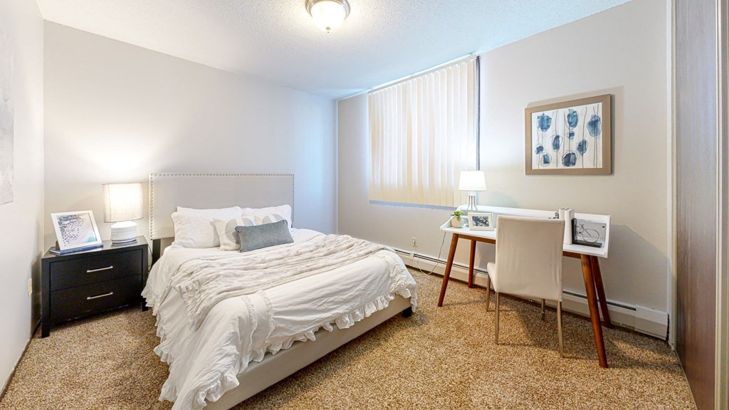 a bedroom with a bed and a desk