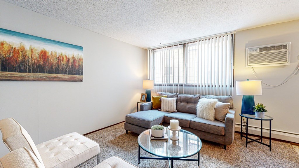 a living room with a couch coffee table and two windows