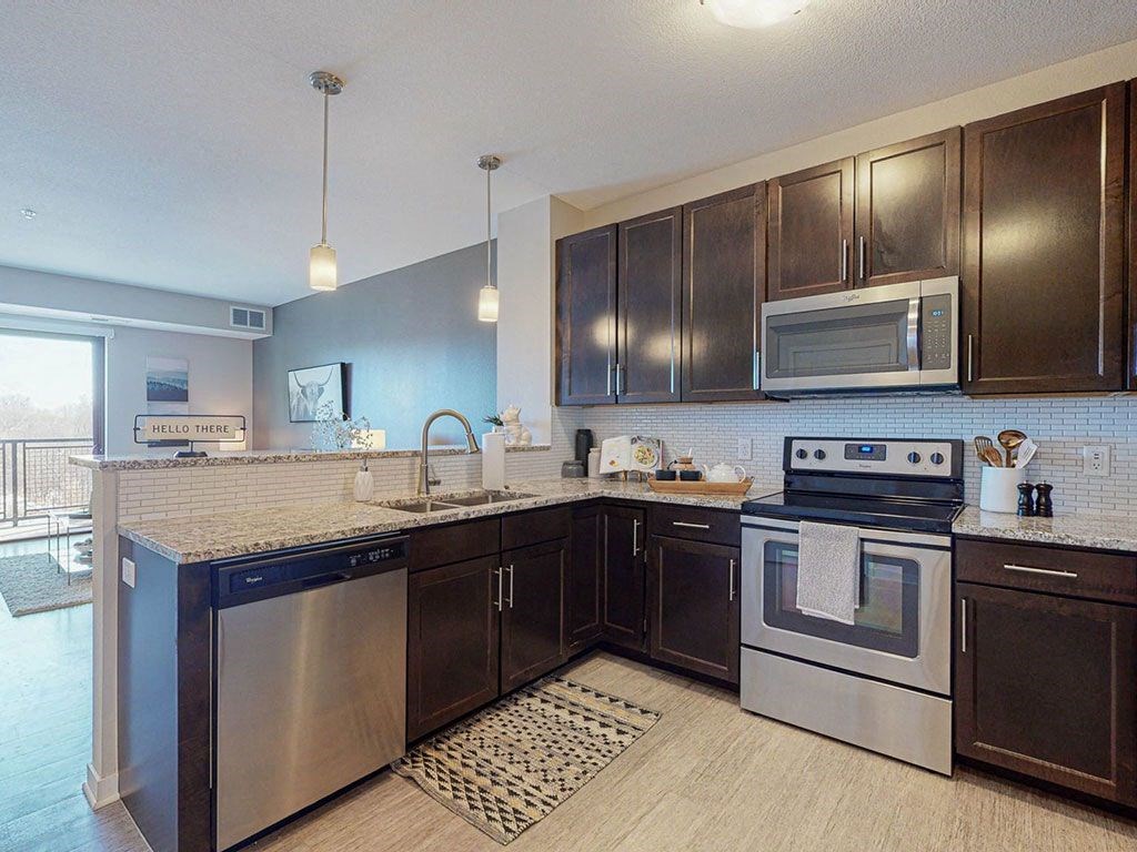 One bedroom apartment, kitchen stainless steel appliances, granite countertops, tile backsplash at The Axis, Plymouth, MN