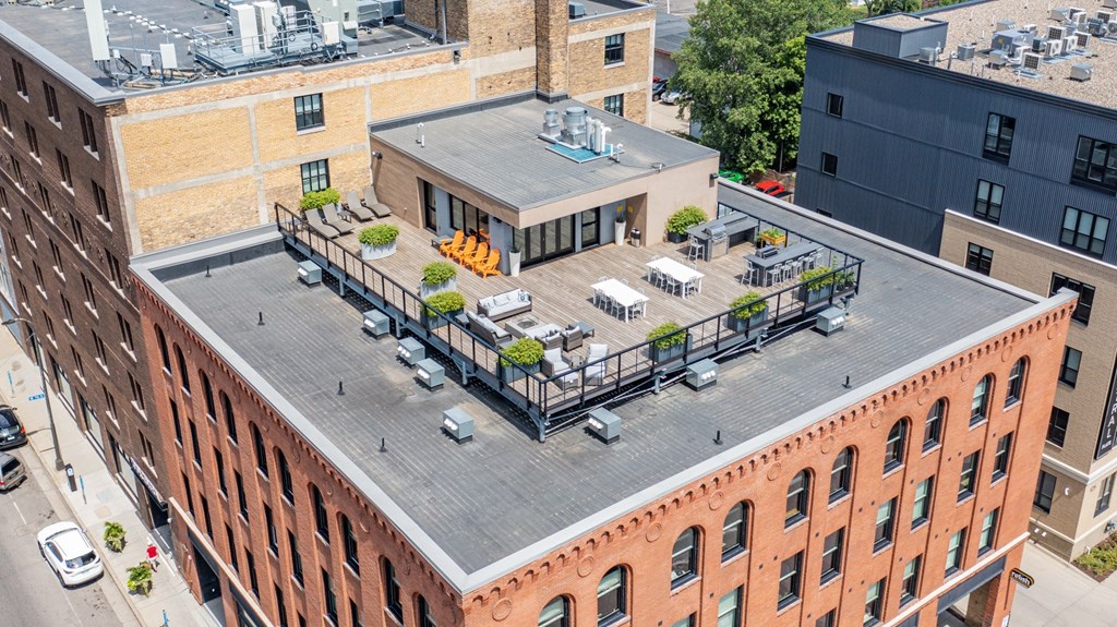 an aerial view of a brick building with a rooftop deck