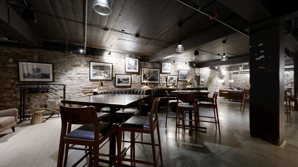 A restaurant with a long table and chairs in the center of the room.