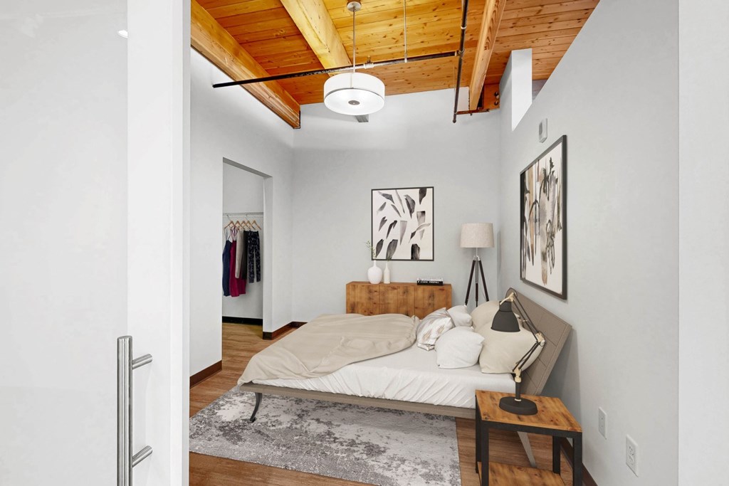 A bedroom with a bed, a bench, and pictures on the wall.