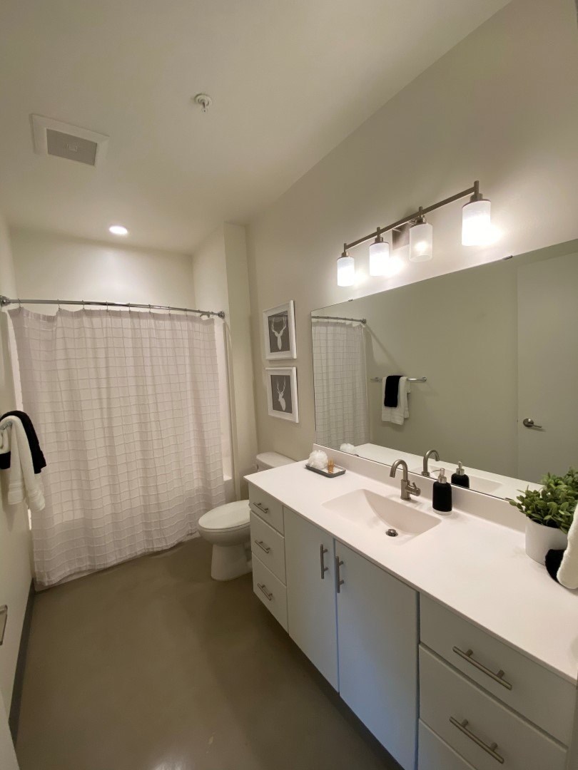 A bathroom with a white sink and a white toilet.
