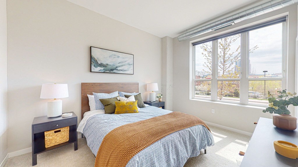 a bedroom with a large window and a large bed