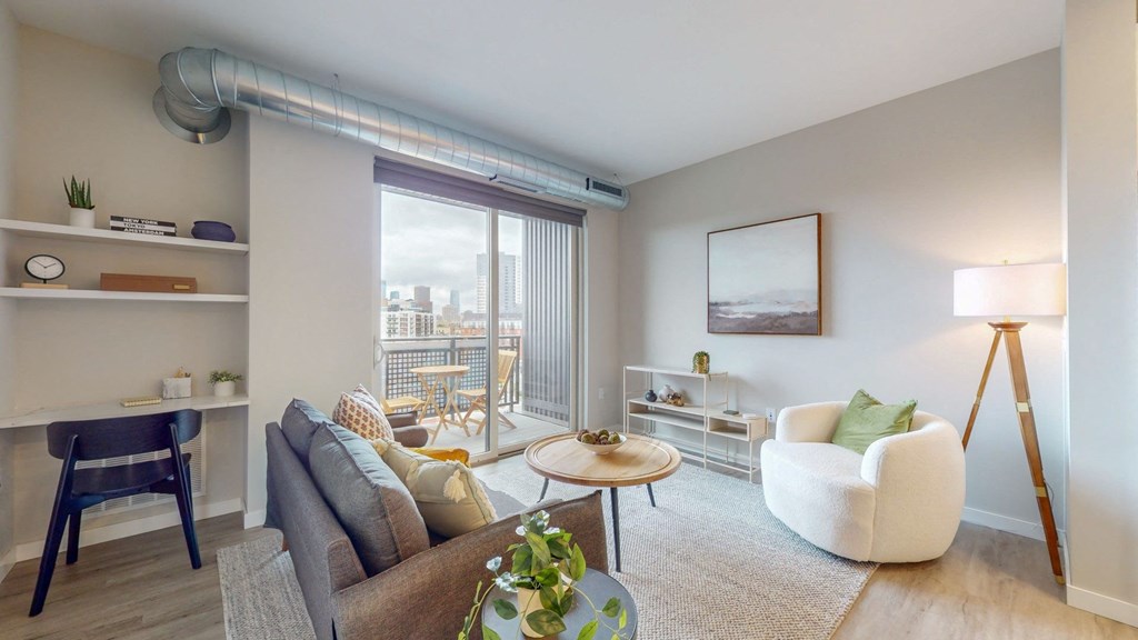 a living area with a couch chair coffee table and sliding glass door to a balcony