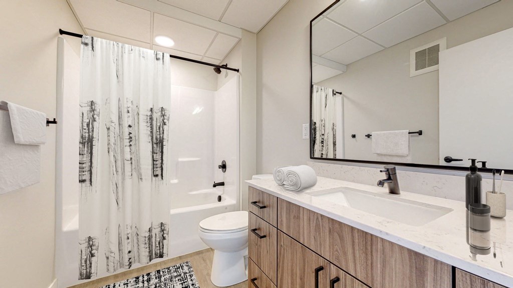 a bathroom with a toilet sink and shower in a 555 waverly unit