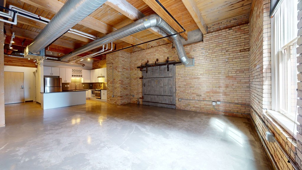 a large room with a kitchen and a large window