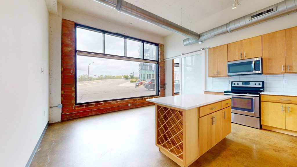 a kitchen with wood cabinets and a large window